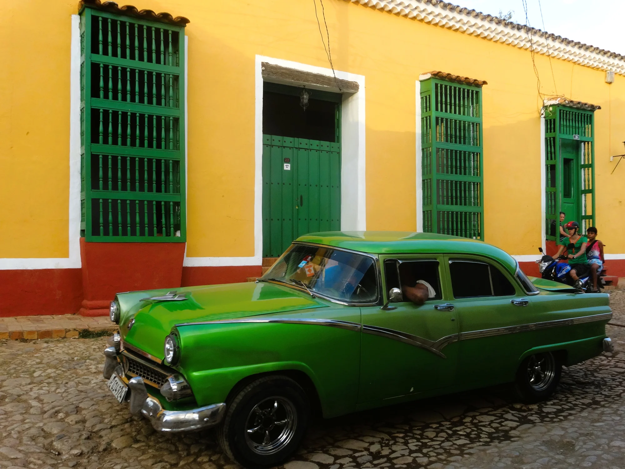 Voiture américaine ancienne verte devant une façade jaune aux portes et fenêtres vertes, Trinidad (Cuba) — La vie en vert